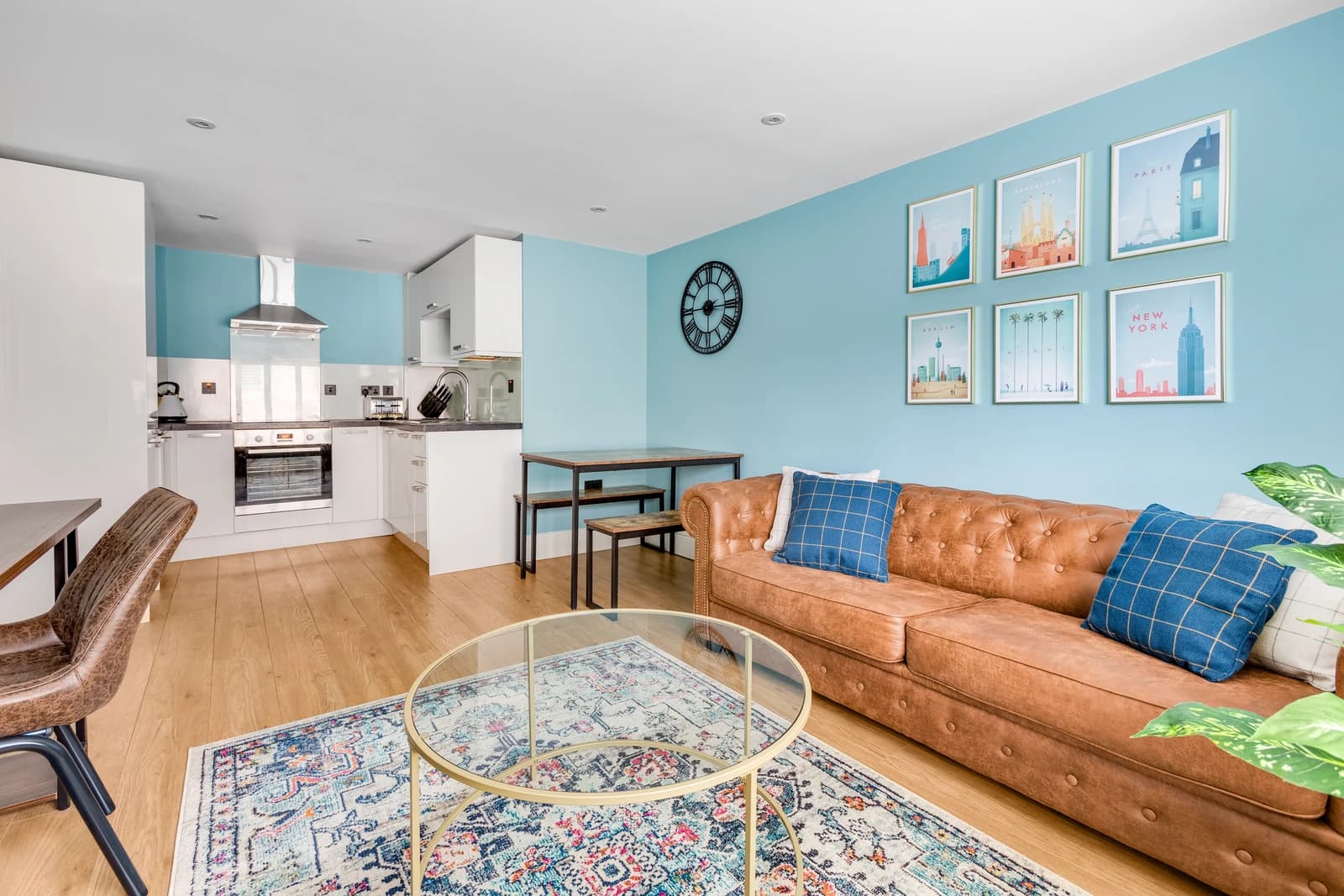 Open-plan kitchen, dining and living area with tan sofa at Station Road Flat 52a, Egham