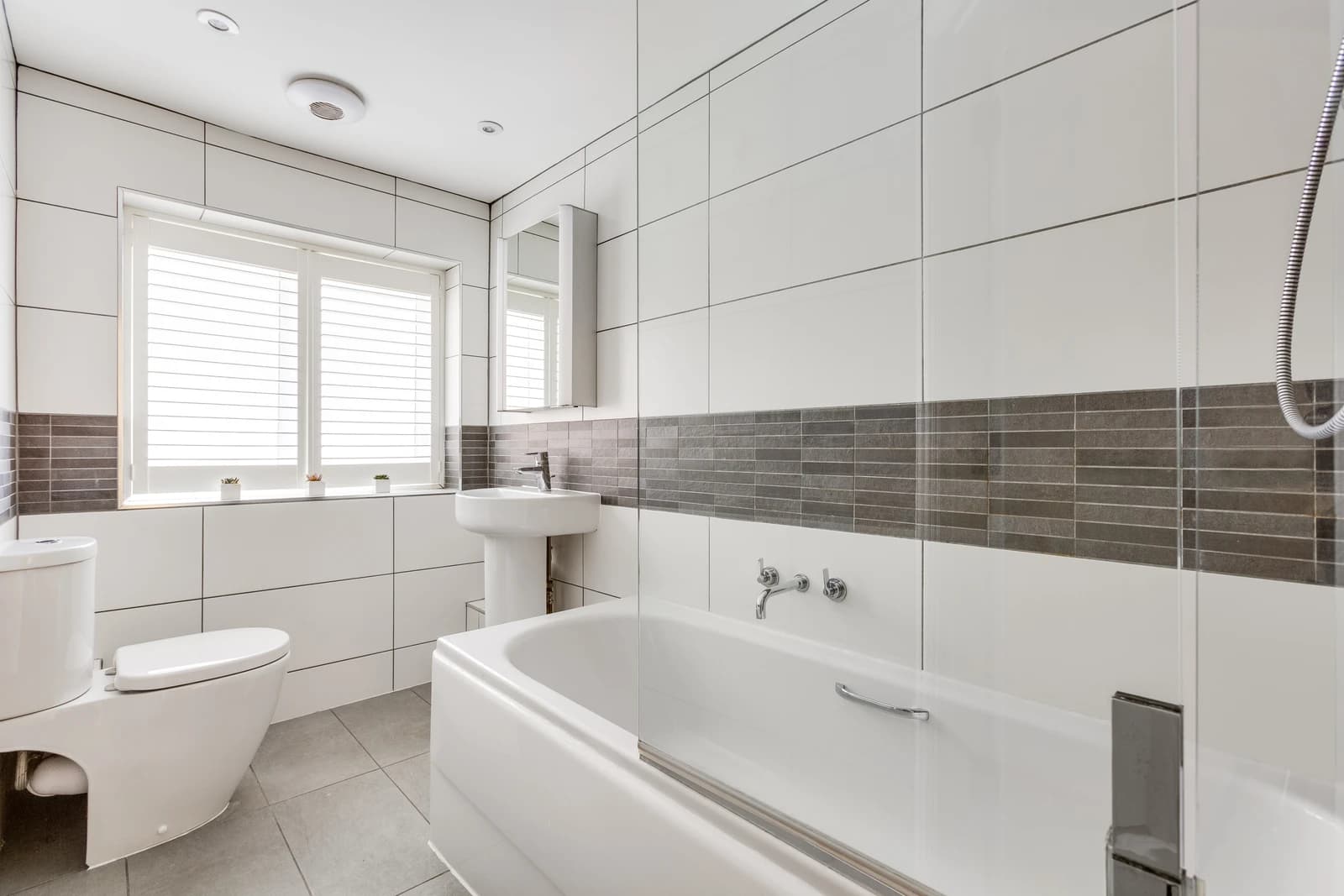 Modern white bathroom with walk-in shower and tiled walls at Station Road Flat 52a, Egham