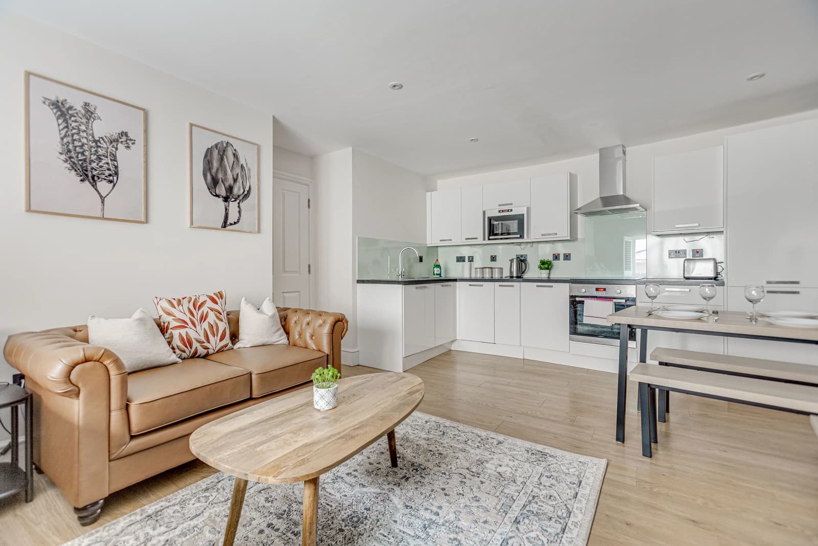 Living room with leather Chesterfield sofa, coffee table and wall art at Boon House, Egham