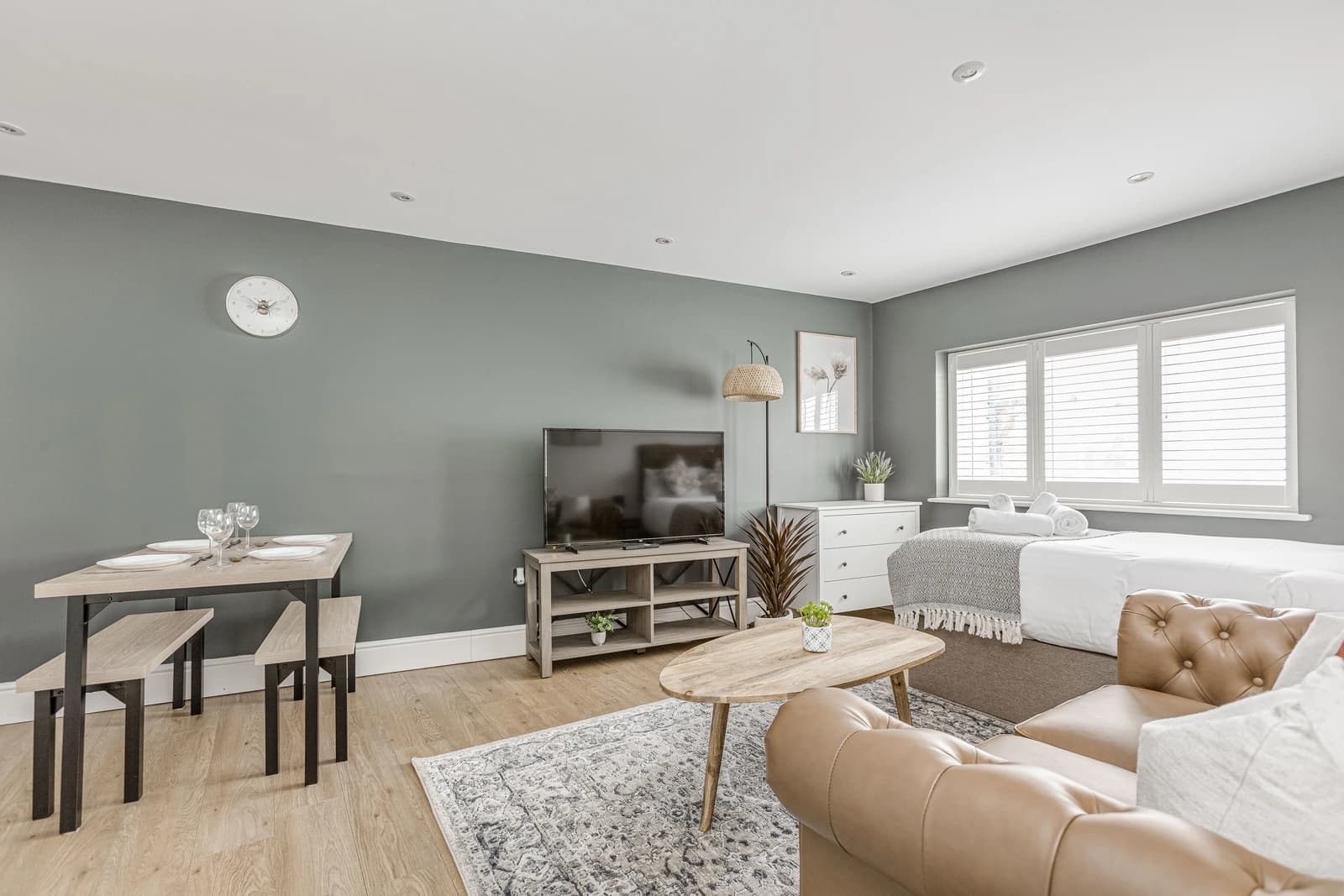 Bright living room with tan leather sofa, cushions and natural light at Boon House serviced apartment