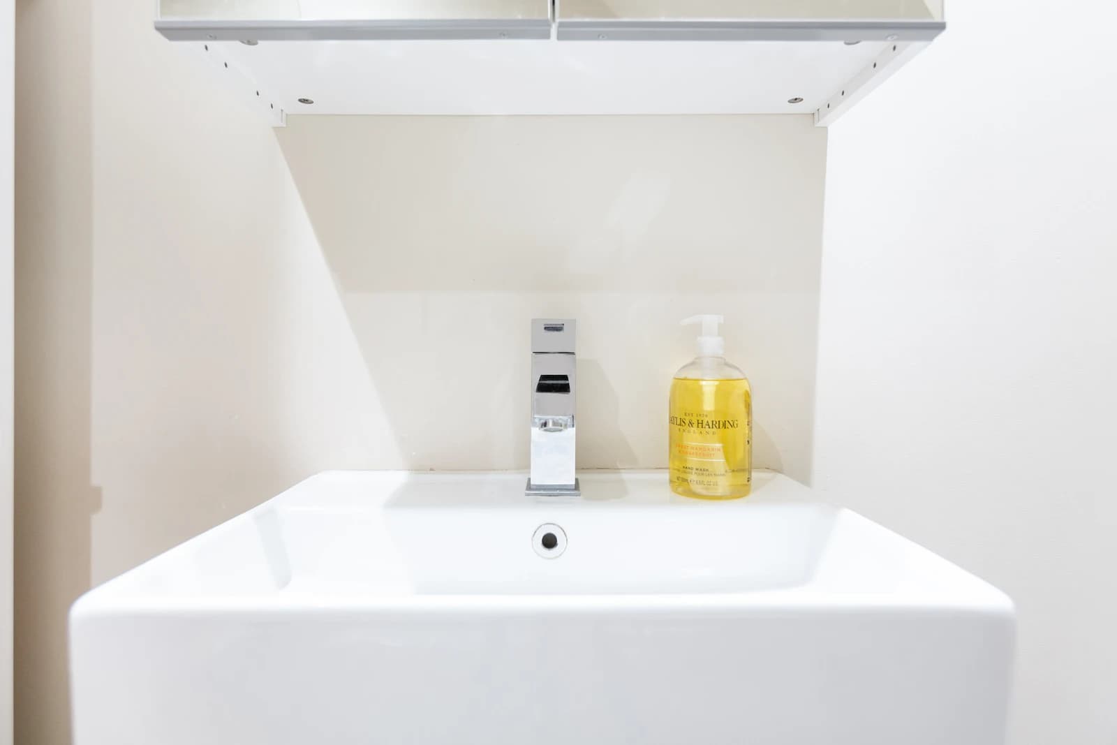 Modern white bathroom sink with soap dispenser at Boon House Flat 3 serviced apartment