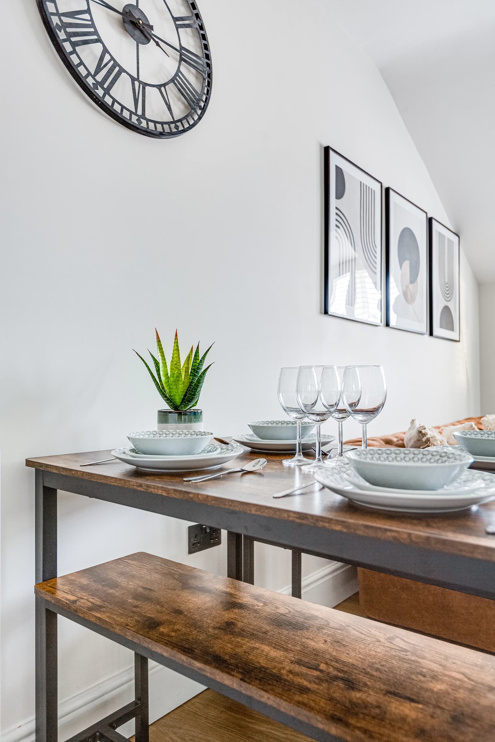 Dining table set for four with wine glasses and plant at Boon House Flat 3 apartment
