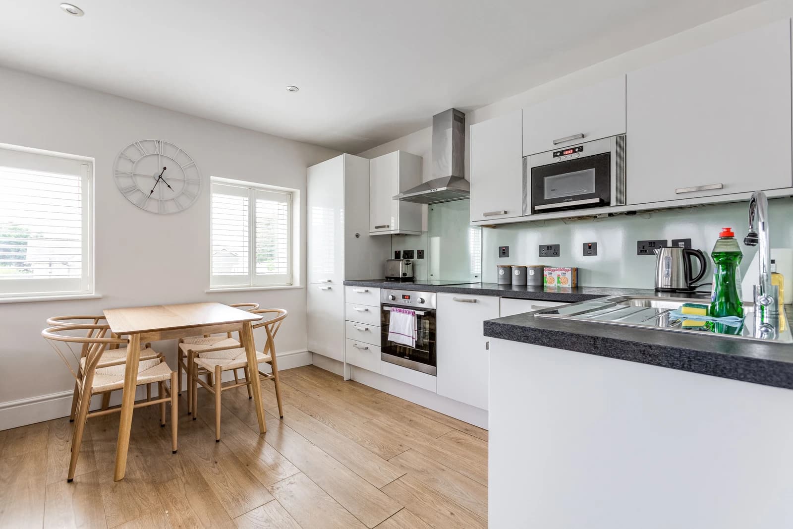 Kitchen and dining area with wooden flooring and integrated appliances at Boon House Flat 2