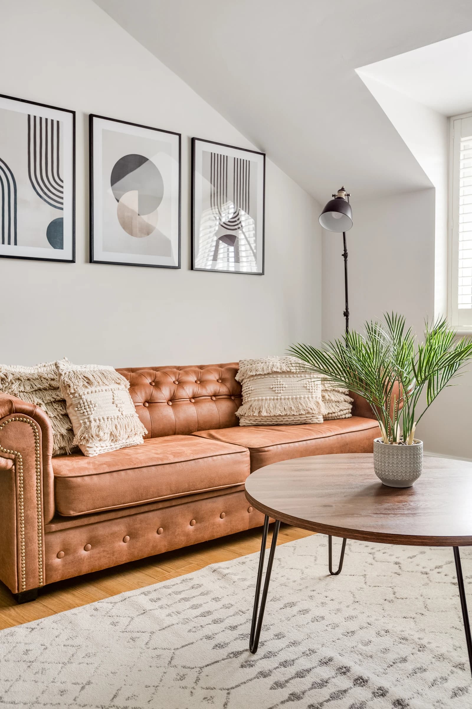 Tan leather sofa with cushions and indoor plants in the living area at Boon House Flat 3