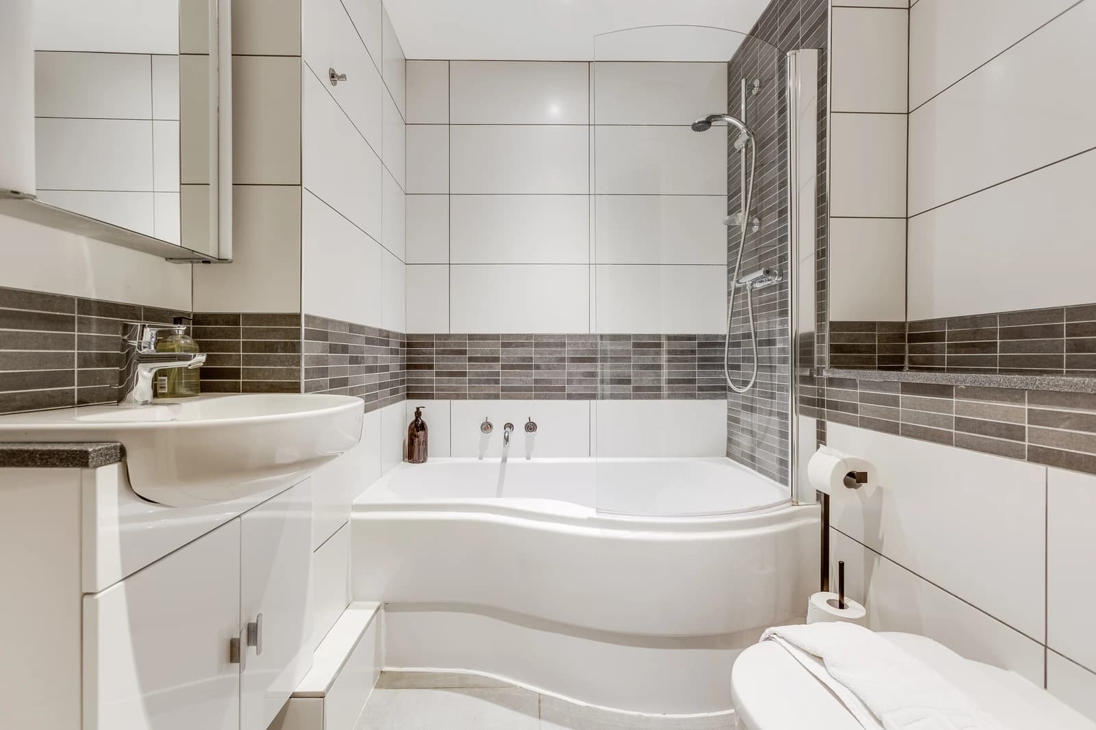 Modern bathroom with bath, shower and tiled walls at Boon House Flat 2, Egham