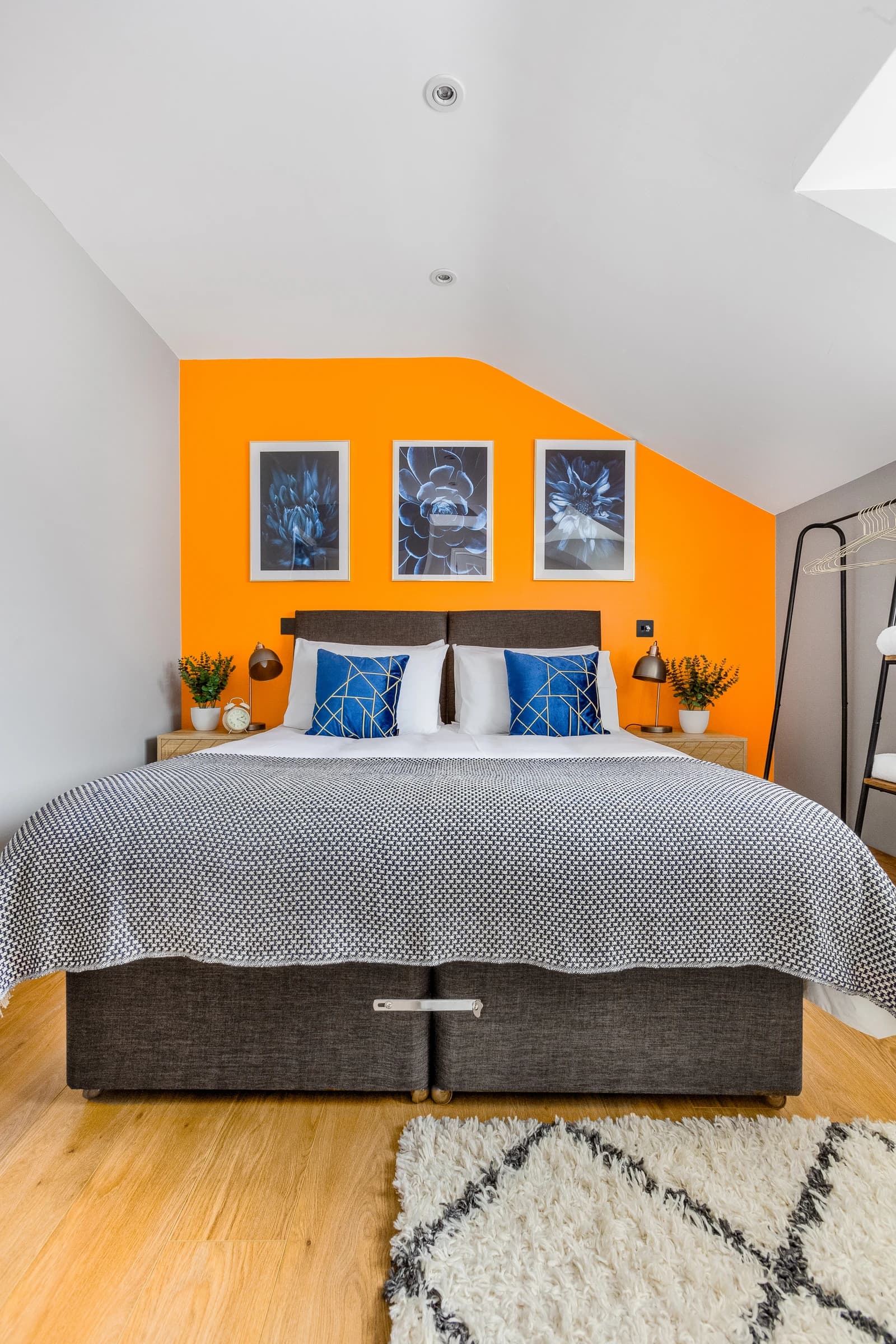 King-size bed with blue cushions and orange accent wall at Boon House Flat 3 apartment