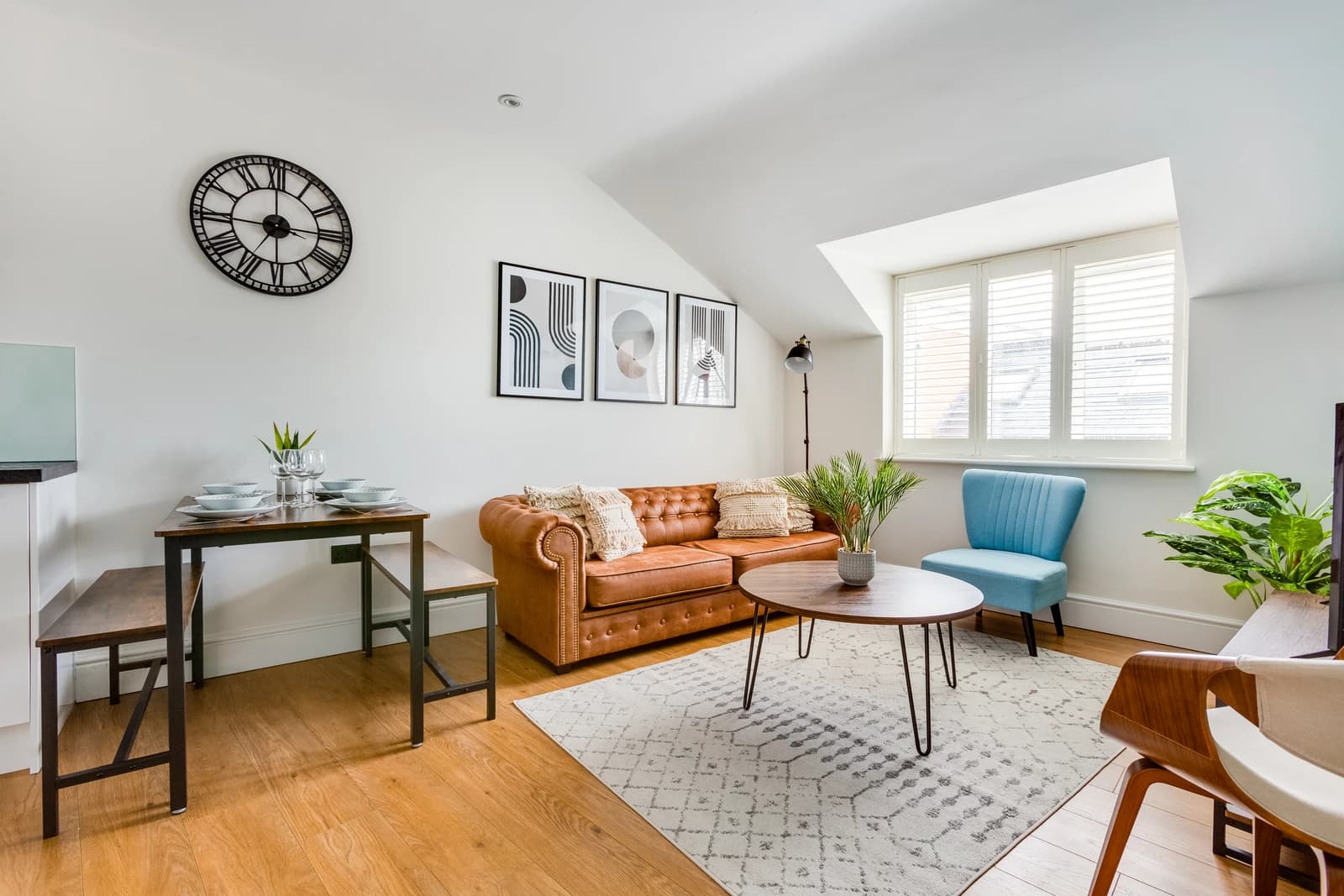 Open-plan dining and living area with blue chairs and wooden table at Boon House Flat 3, Egham
